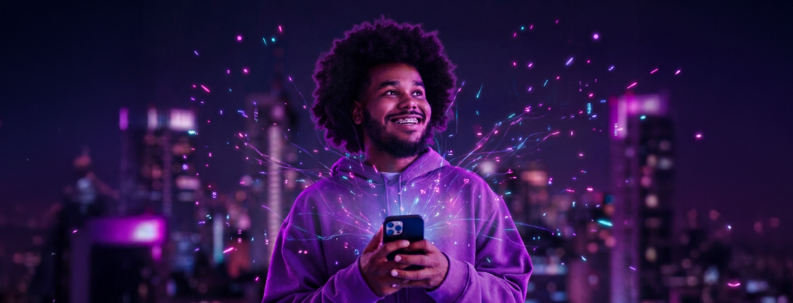 Jovem sorridente segura um celular com uma cidade ao fundo, representando o acesso a cursos gratuitos online
